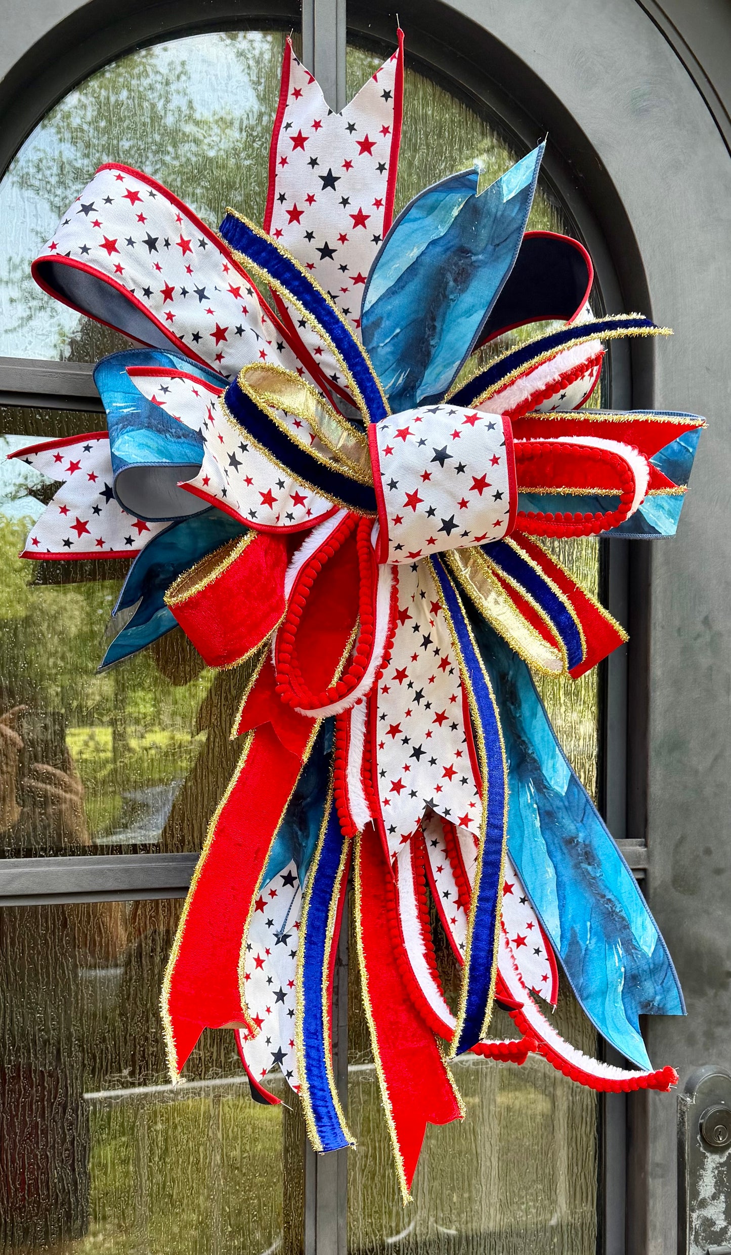 JME lux Patriotic bow with STAR ribbon. Hand-tied by JME. Approximately 22 inches wide and 32 inches long.