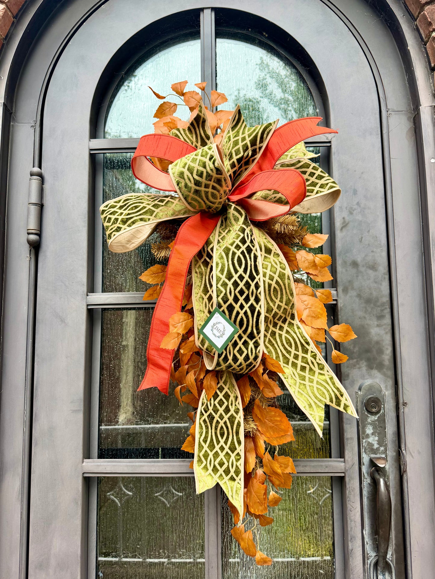 Handmade JME fall door swag made with faux fall leaves and paired with a beautiful green embroidered JME bow. About 3 feet long by 21 inches wide. *Some fluffing may be required upon receiving. 