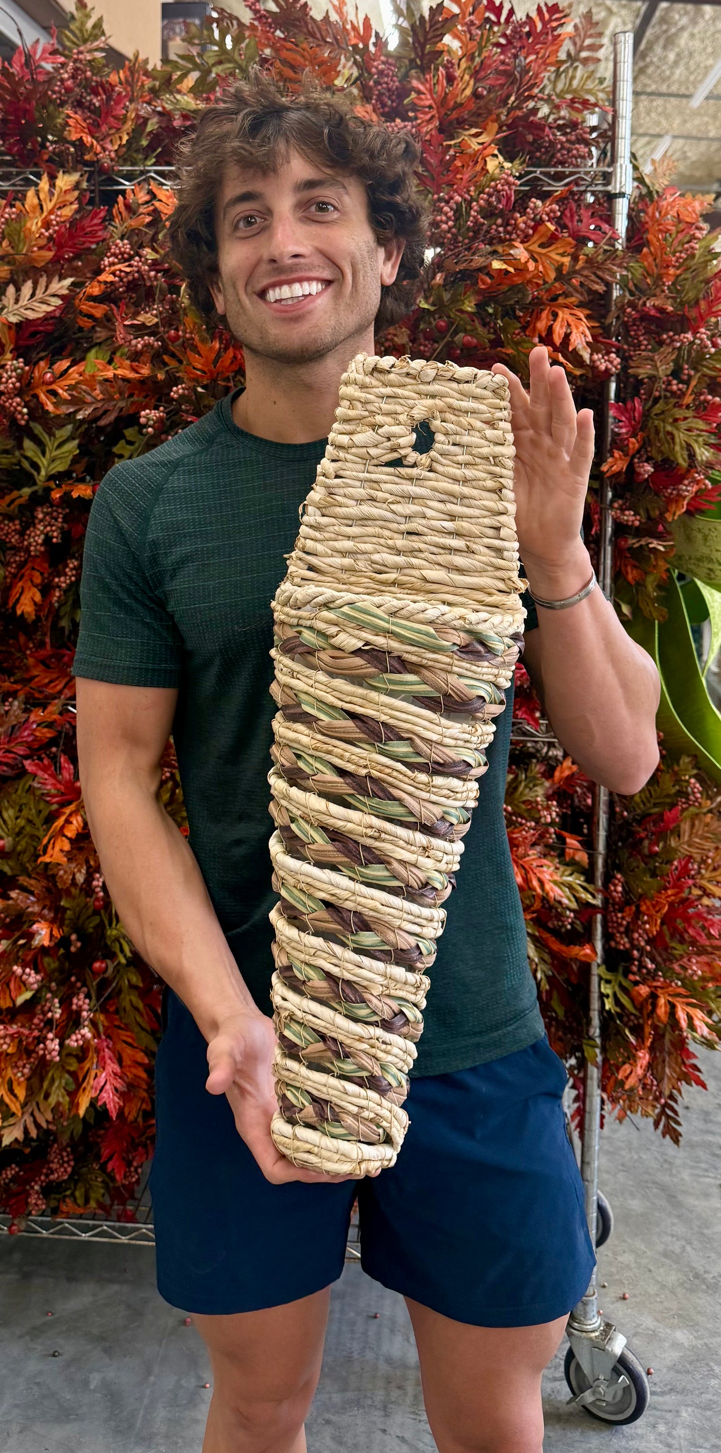 Small cone woven basket with plastic liner. 24 inches long by 8 inches wide.