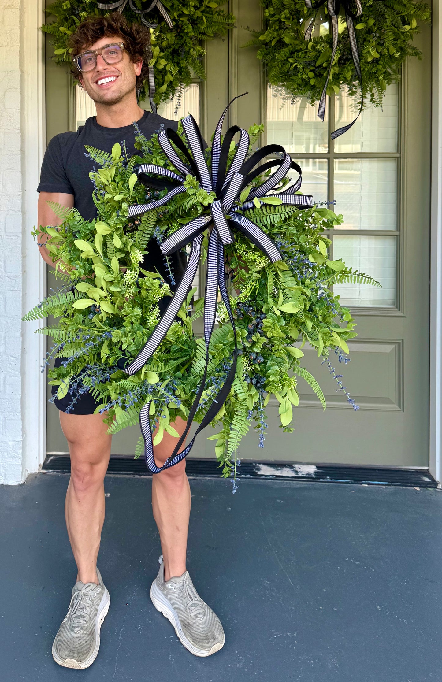 JME Faux mixed greenery with BLUEBERRIES and a JME HAND TIED black/white checked BOW. About 24inches wide.
