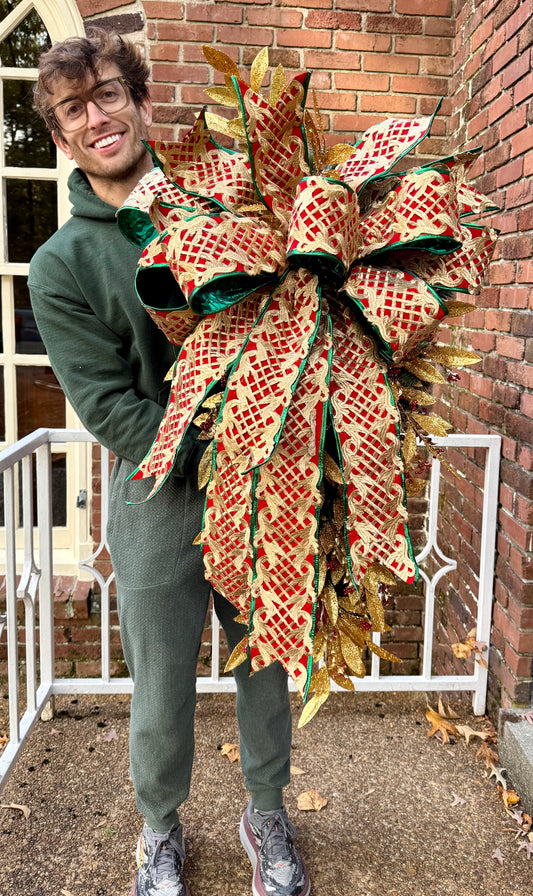 JME regal Christmas swag. Red and gold with a touch a green and tied with a JME hand tied bow. Has jingle bells. About 4 feet long by 2 foot wide.