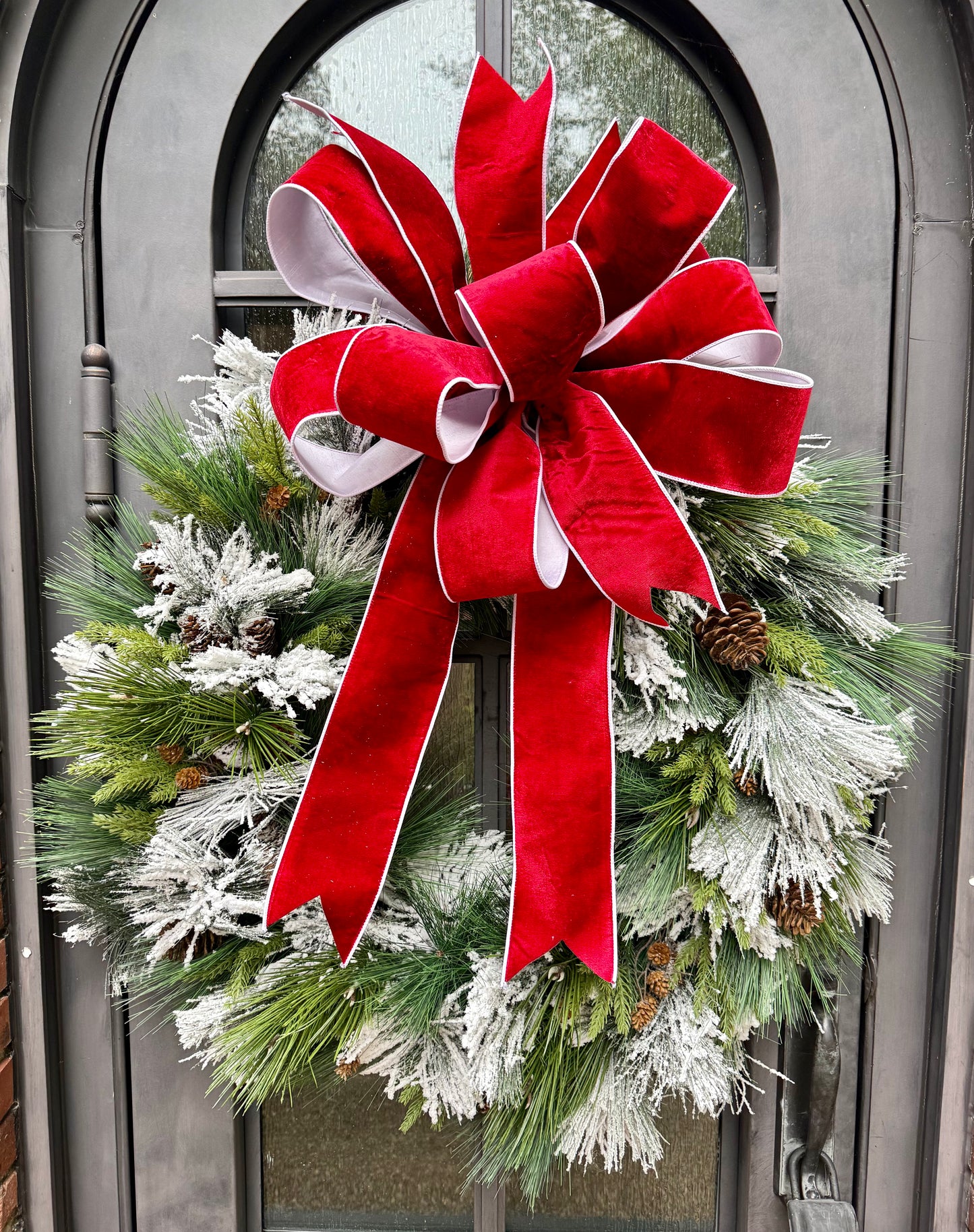 Big Flocked mixed foliage wreath with a JME hand tied bow in it. Red velvet backed with white taffeta. 36inches wide