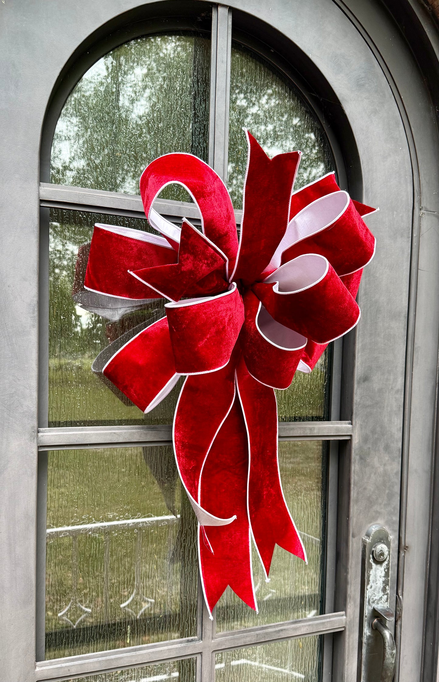 JME hand tied though about 20 inches wide. Made with JME red velvet ribbon with white backing. Some fluffing may be required upon receiving.