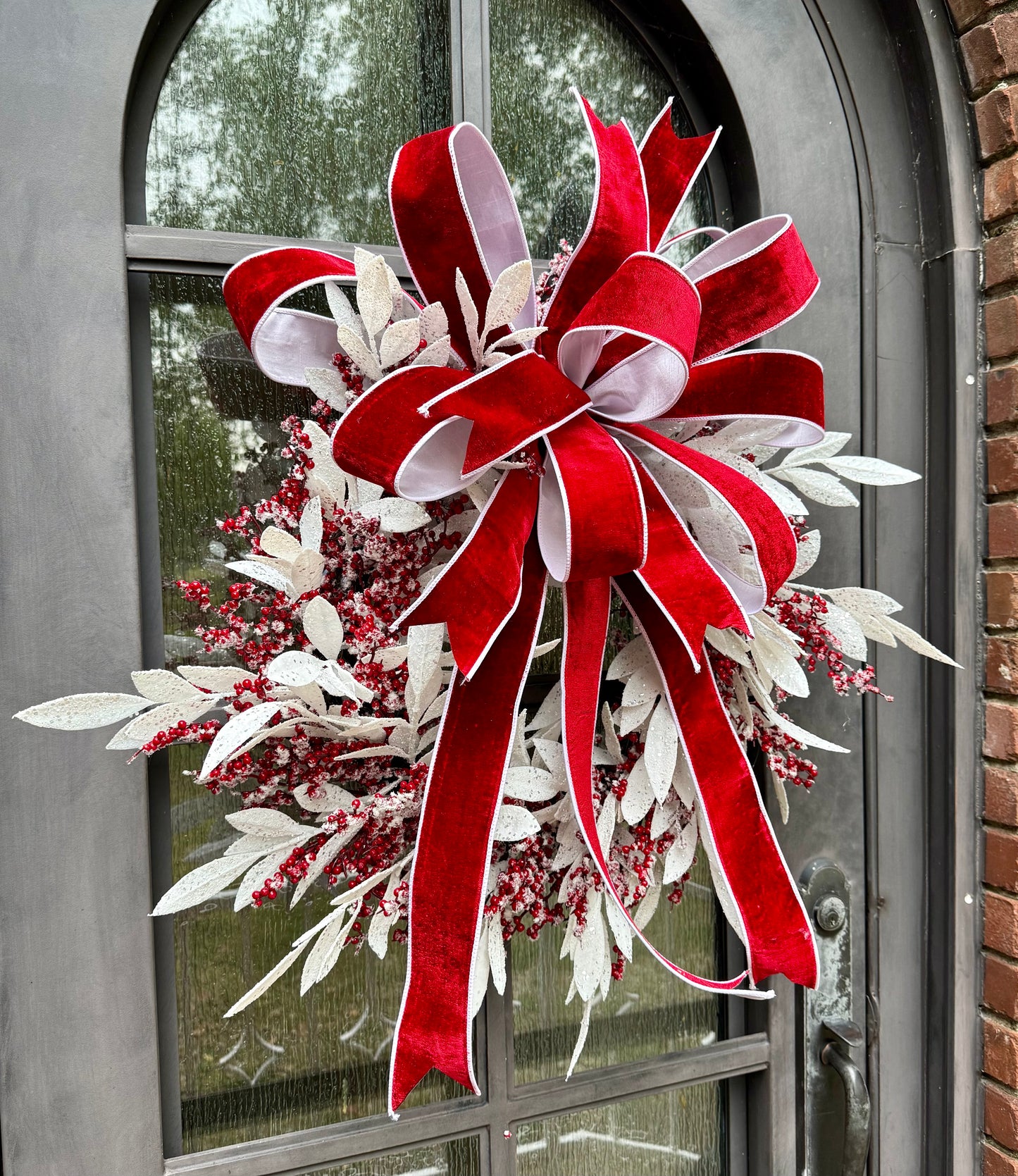 Handmade JME wreath. White icy bay leaves, and icy berries. with a hand tied JME red velvet bow. About 24 inches wide.