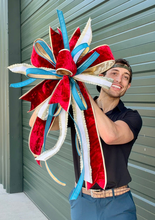 JME regal patriotic hand tied bow using JME ribbons. Some fluffing may be required upon receiving. Bow is about 23 inches wide by 30 inches long.