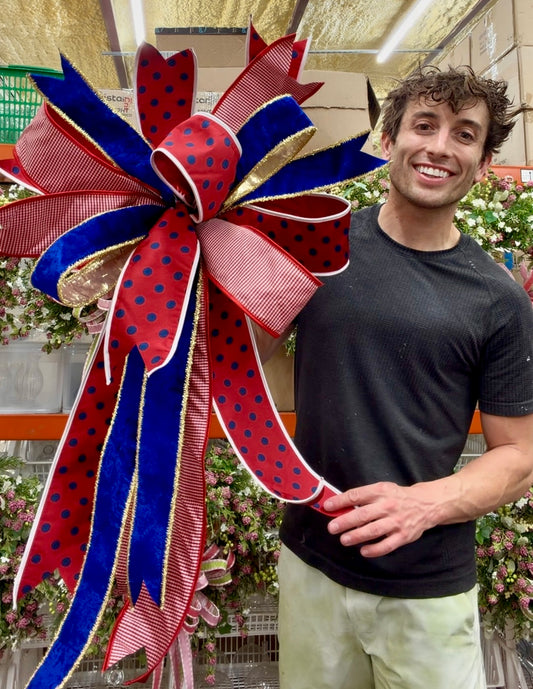 JME hand tied patriotic bow with red and navy polkadot ribbon. Some fluffing may be required upon receiving. About 20 inches wide by 40 inches long.