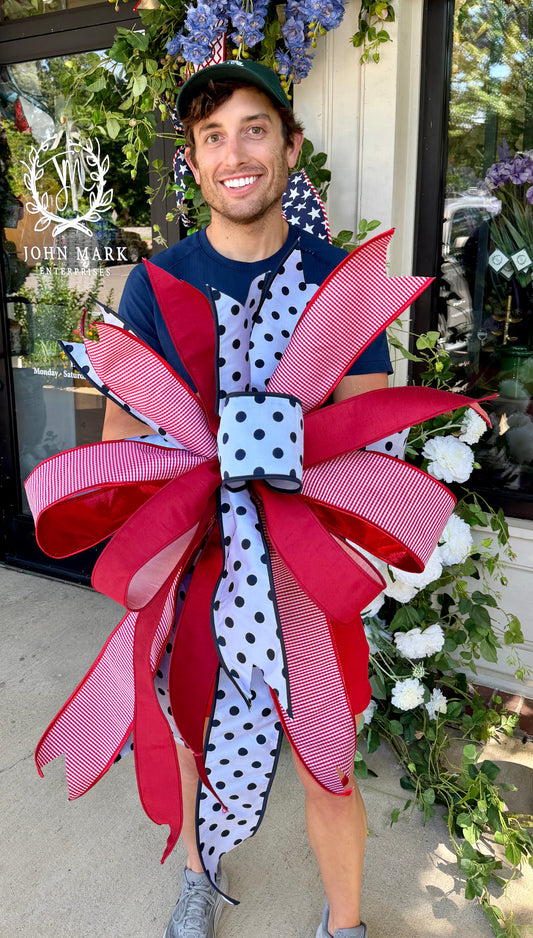 JME white with navy polka dots bow. Hand-tied by JME. Approximately 23inches wide and inches 32inches long.