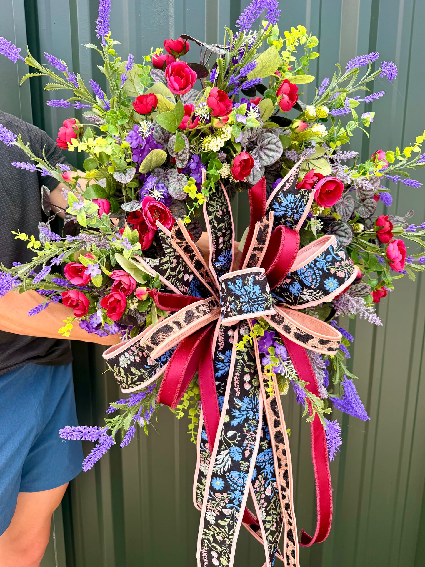 JME HANDMADE WREATH. Lush deep colors of purples and burgundies. Paired with a JME hand tied bow. About 26 inches wide.