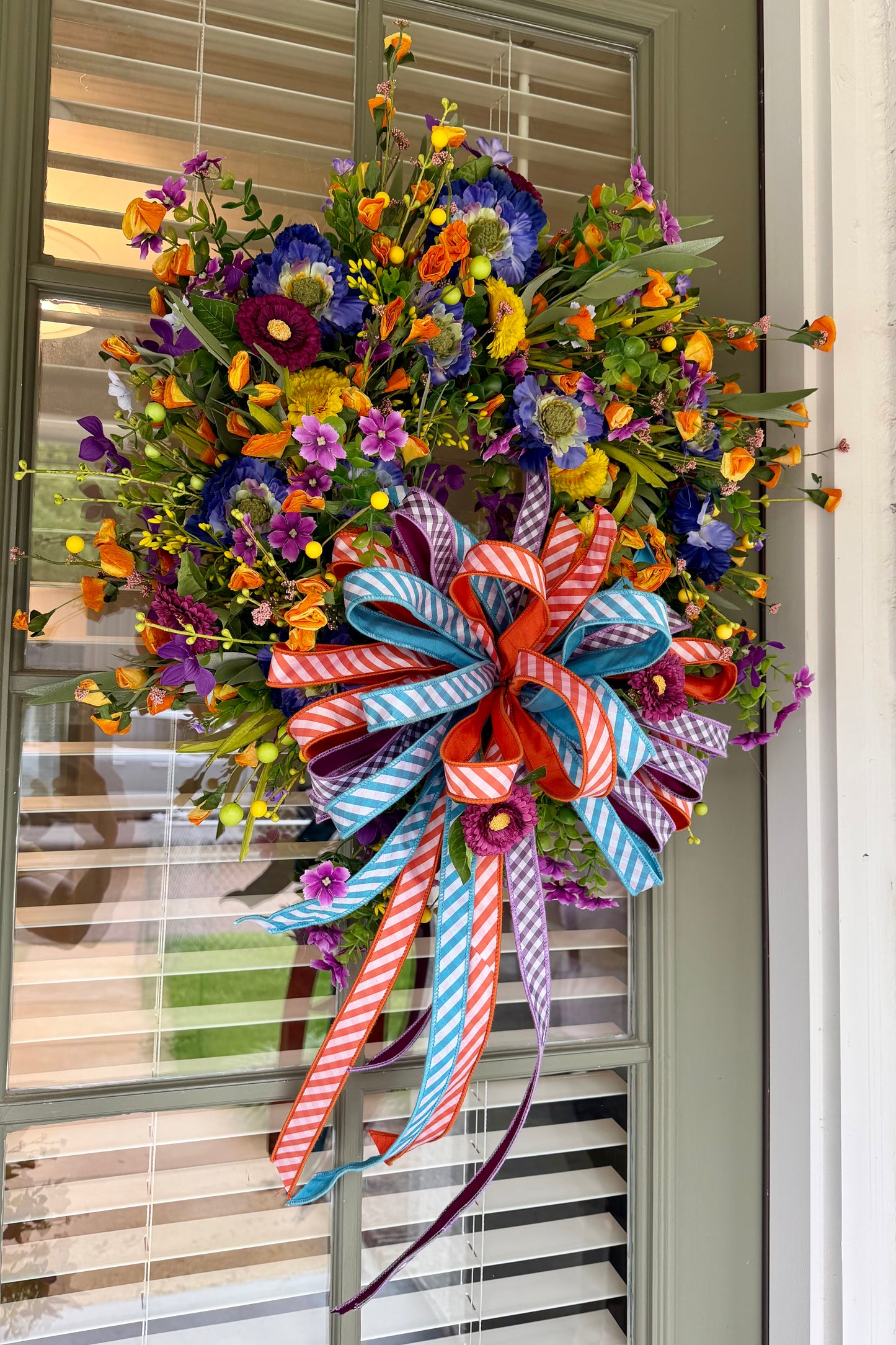 Summertime JME handmade wreath. Made with faux florals and paired with a JME hand tied bow. About 24 inches in diameter.