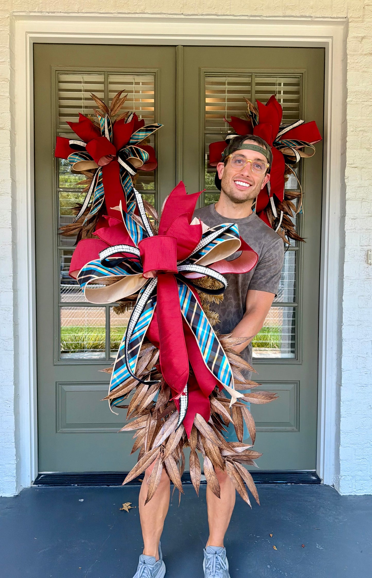 JME faux swag made of BRONZE Bay Leafs  and paired with a JME bow of blue bias plaid ribbon and coordinating colors. About 3 feet long and 21 inches wide. Some fluffing may be required upon receiving.