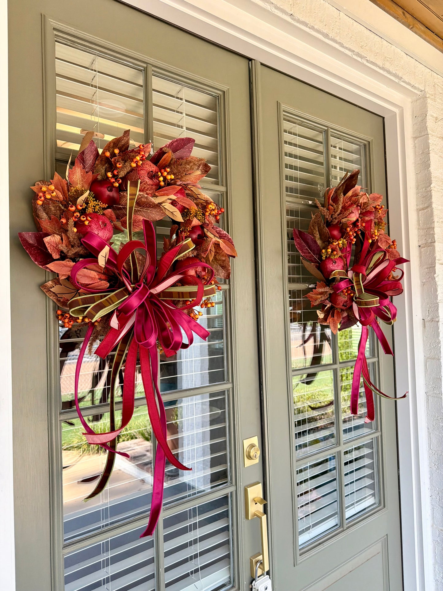 Faux POMEGRANATE fall wreath with a JME hand tied bow of an assortment of 1in ribbons. About 24 inches wide. Some fluffing might be required upon receiving.