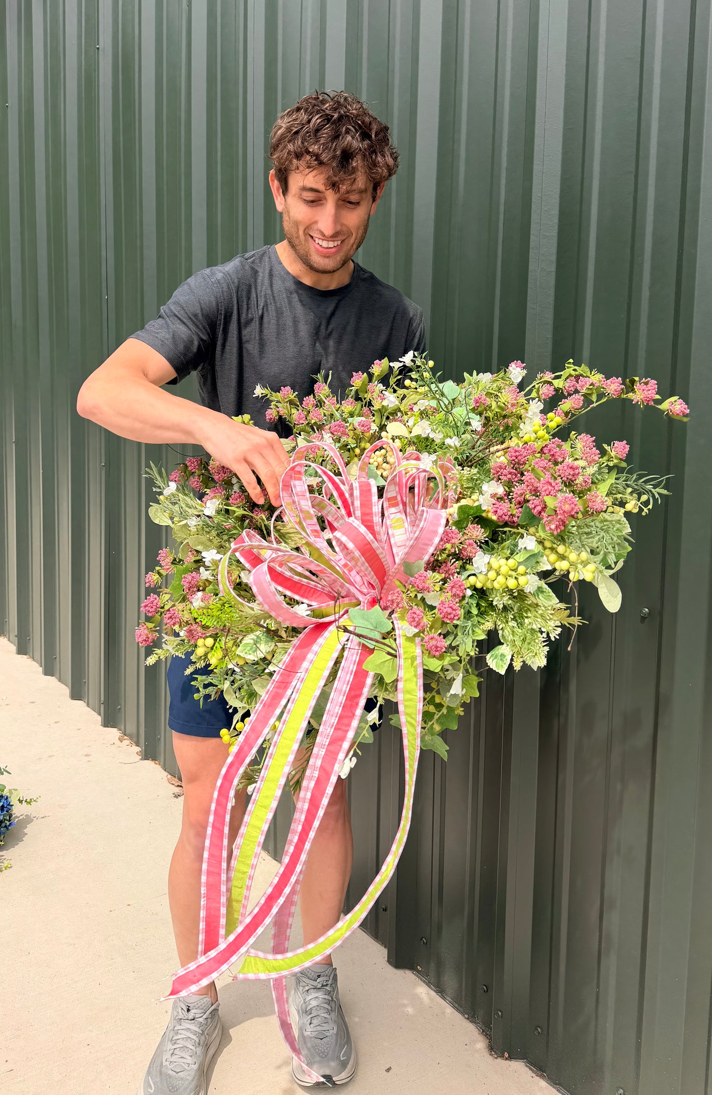 Handmade JME summer meadow wreath. Paired with a JME hand tied bow of 1 in ribbons in pinks, green, and coral. About 24inches in diameter