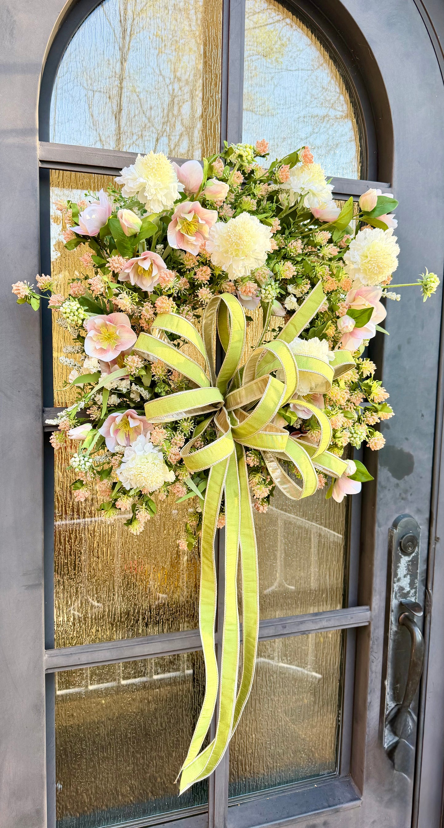 JME handmade wreath of blush, hellebore and white Scabiosa and different mixed florals. Paired with a JME 1 inch green bow. About 24 inches in diameter. ￼
