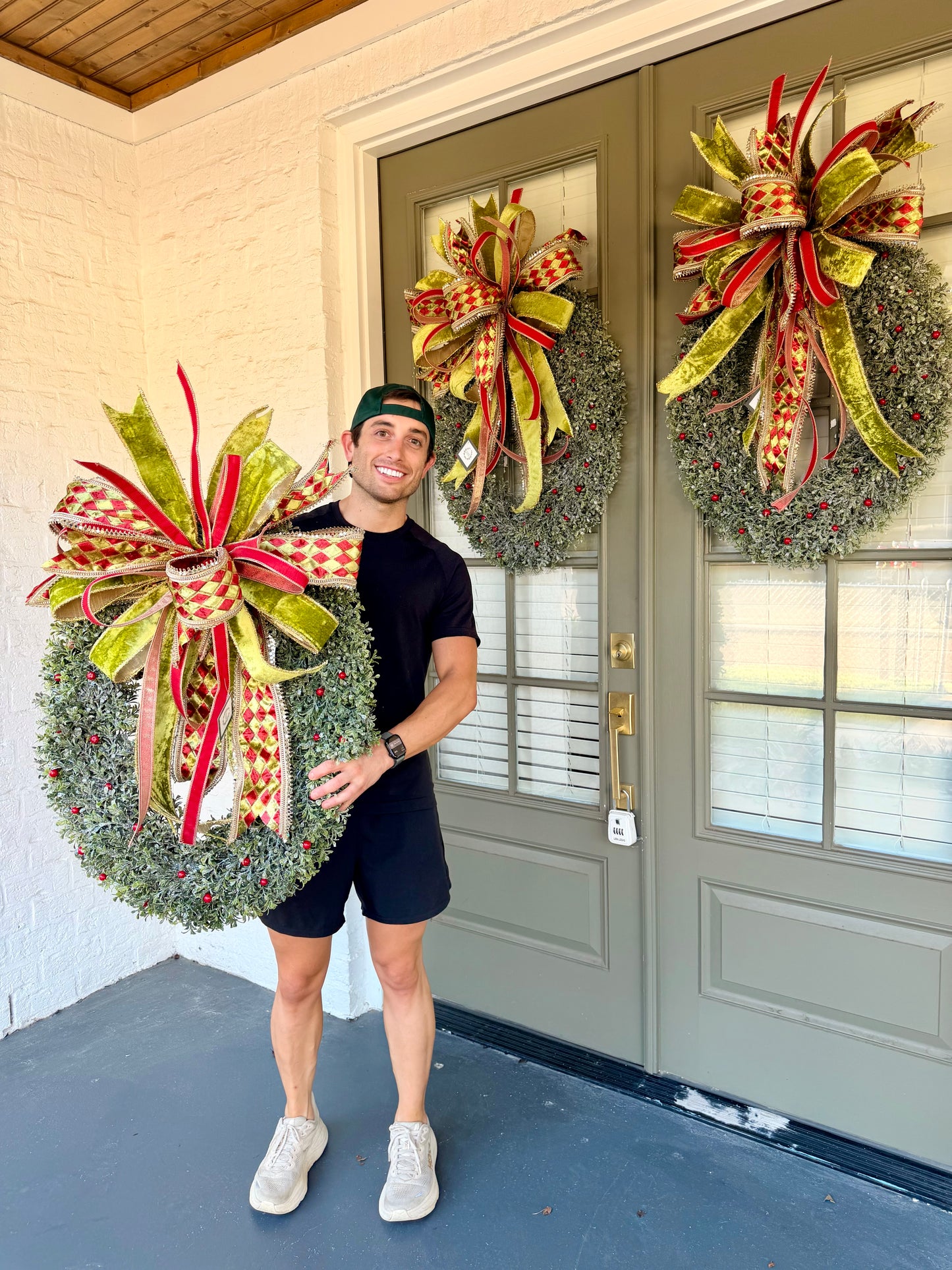 The Oval Wreath. Glittered icy oval wreath paired with A JME hand tied bow. About 22 inches wide and 32 inches long. *Some fluffing may be required upon receiving.