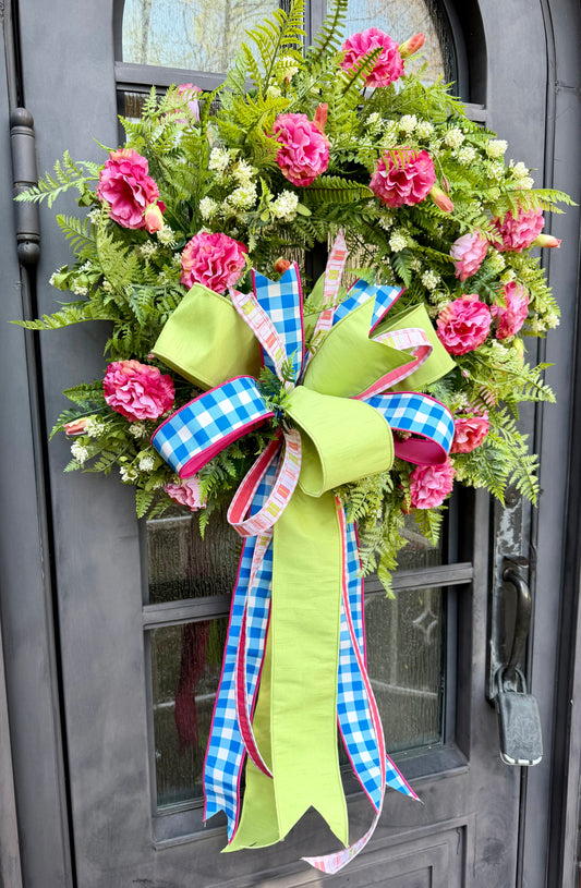 Handmade JME wreath. Made of pink lisianthus, mixed foliage, and wild flowers. Paired with a JME blue and white checked with pops of pink hand tied bow. About 30 inches in diameter.