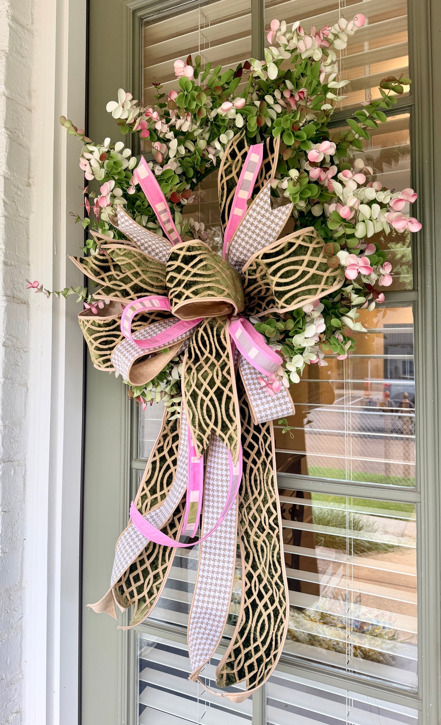 Faux eucalyptus wreath paired with a JME hand tied bow. About 24 inches in diameter.
