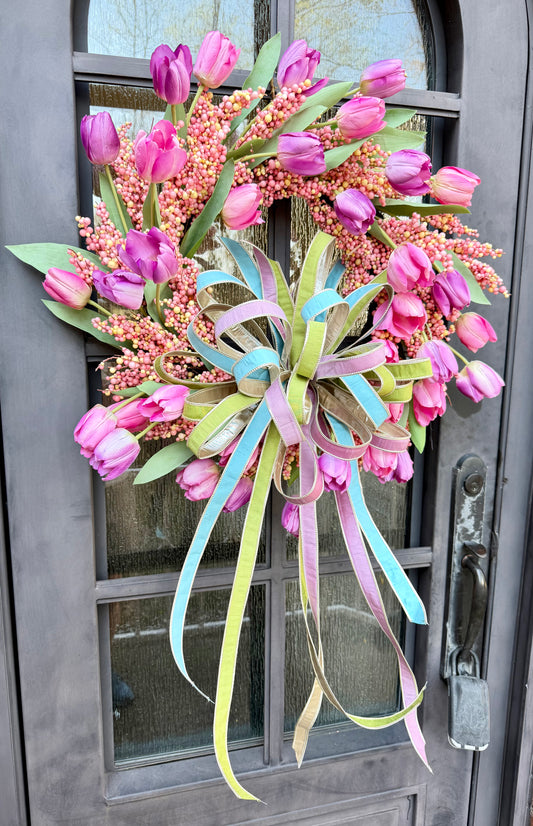 Handmade JME wreath. Made of pink berries and pink and purple tulips. Paired with a JME soft blue, lavender, and green hand tied bow. About 24 inches in diameter.