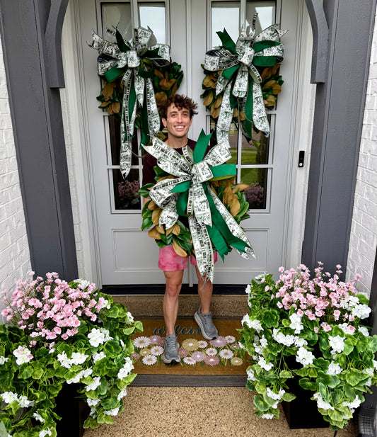 24 inch faux magnolia wreath with a hand tied JME green toile inspired bow.