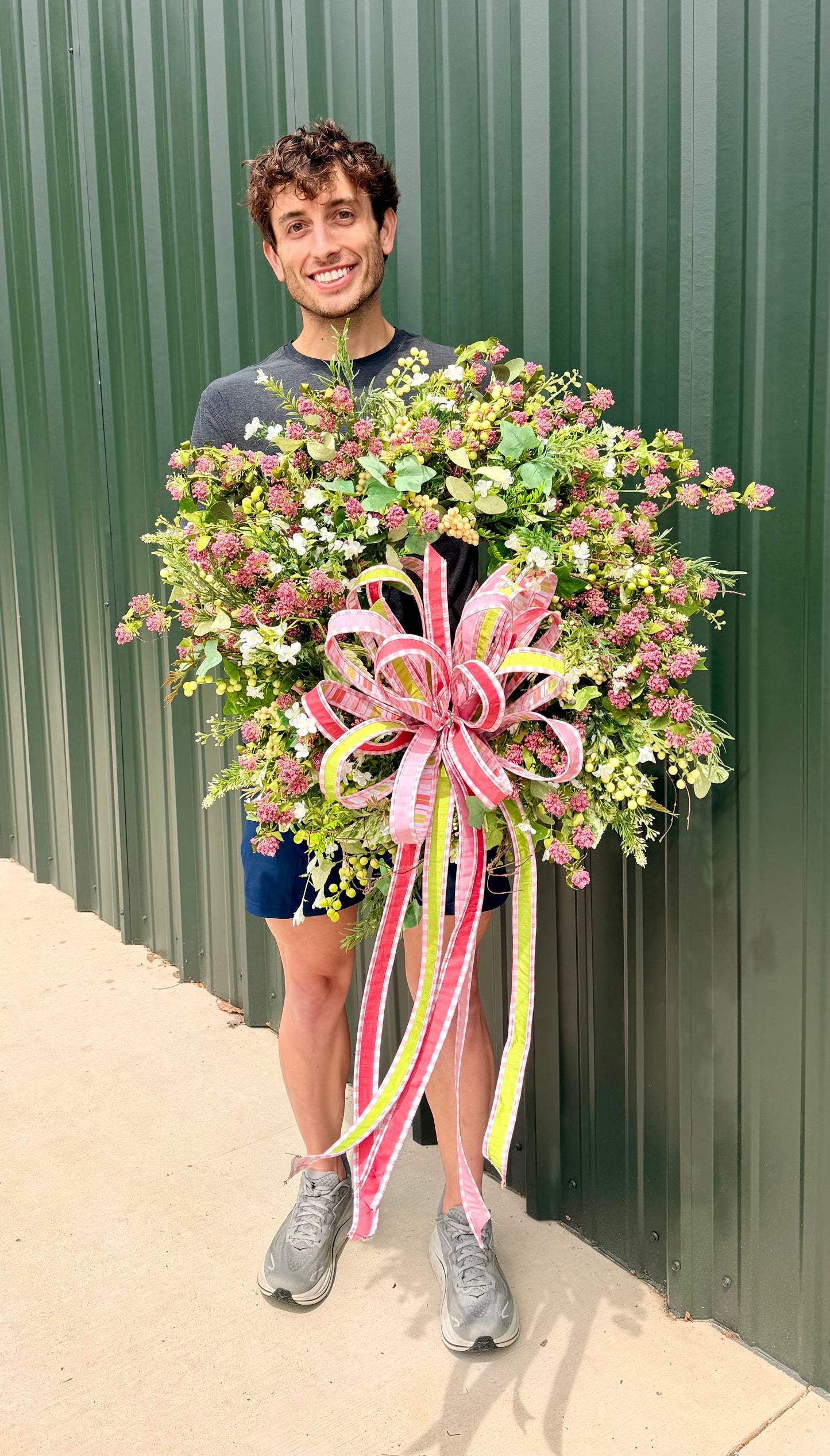 Handmade JME summer meadow wreath. Paired with a JME hand tied bow of 1 in ribbons in pinks, green, and coral. About 24inches in diameter