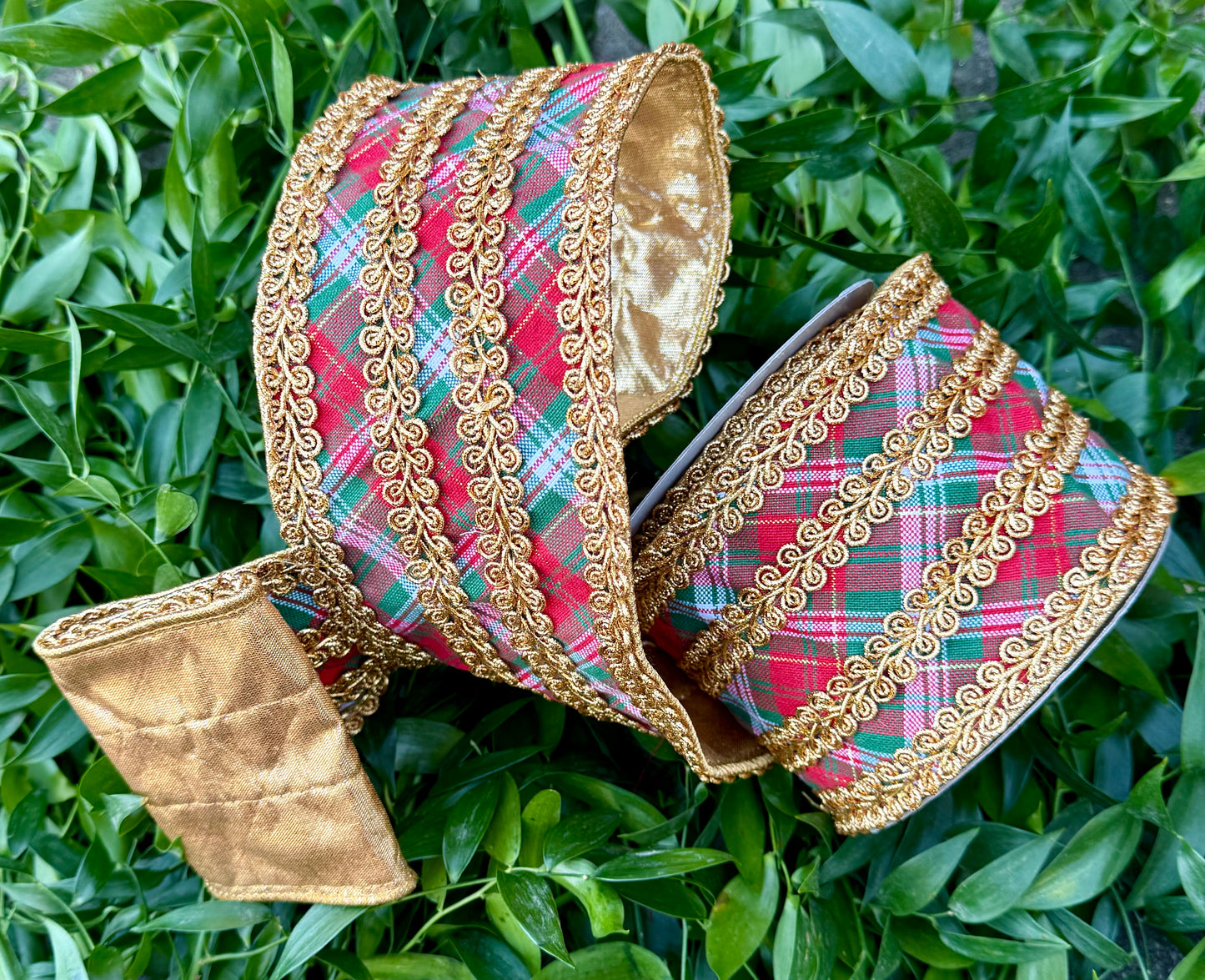 JME heavy wire ribbon. Traditional red green white plaid with gold embroidering belts down the center and on the edge. Backed with the gold metallic. 4“ x 5 yards.