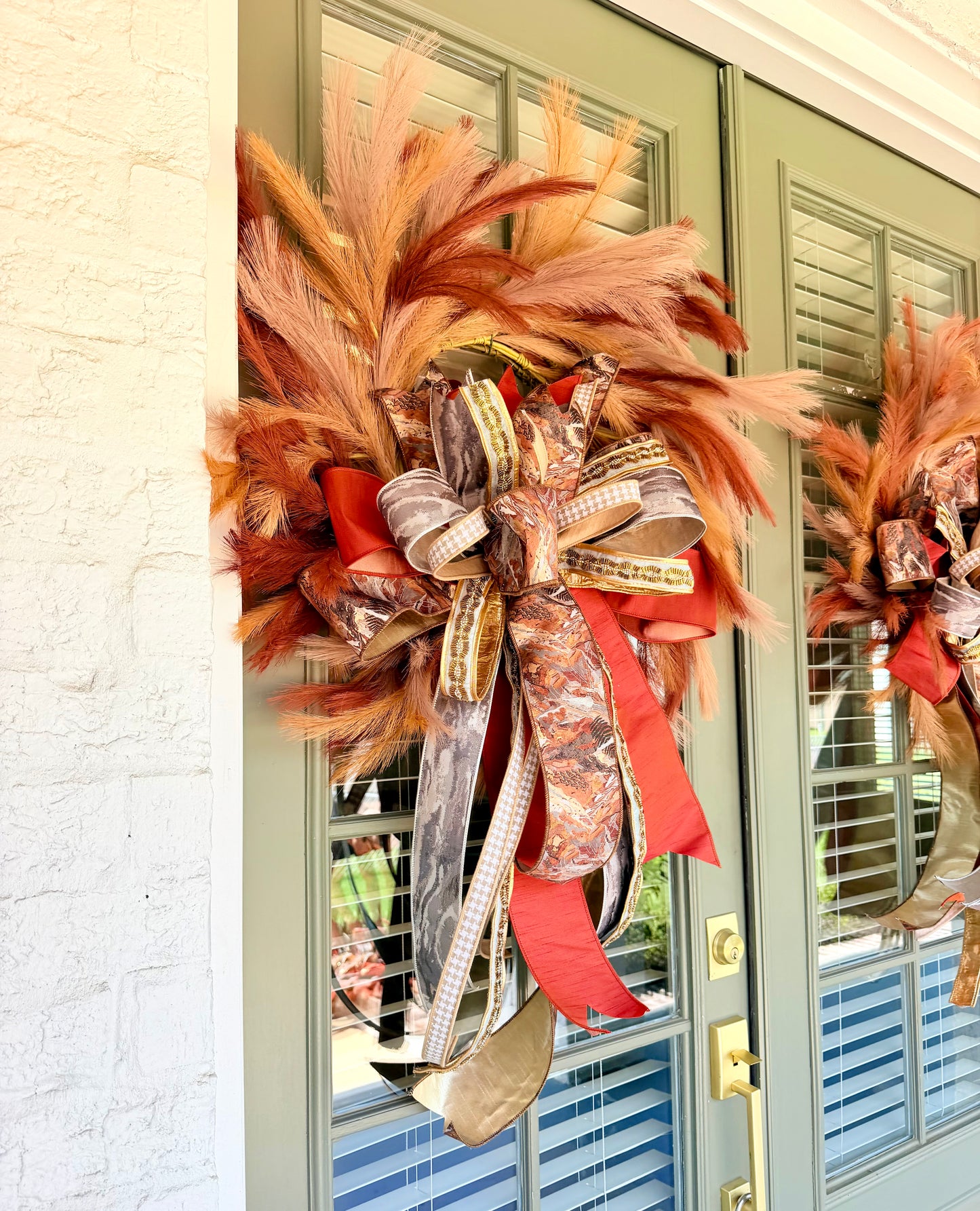 Faux natural and tans plume wreath. Paired with a JME hand tied bow of orange ribbon and fall tones. About 26 inches in diameter. * some fluffing may be required upon receiving.