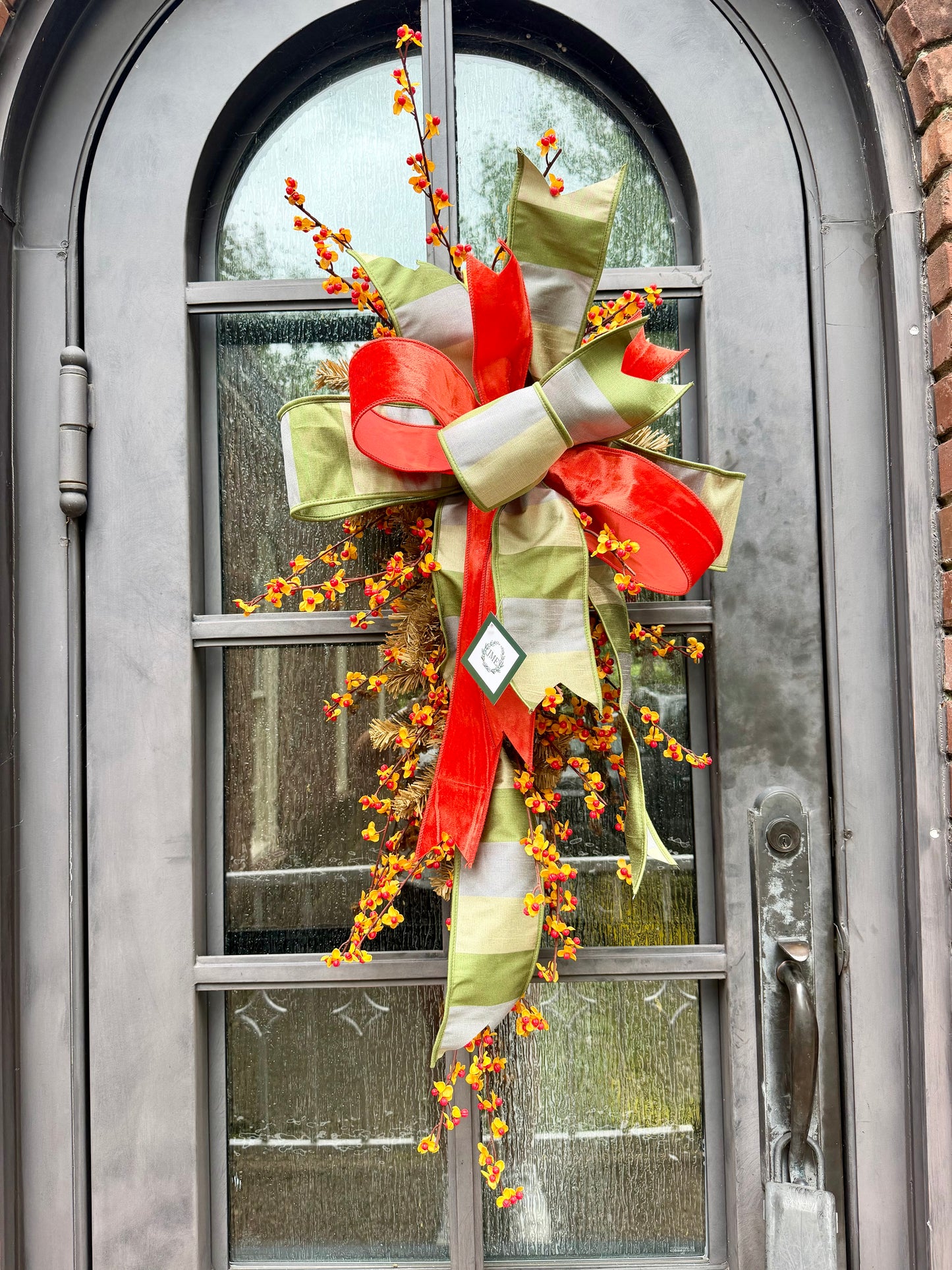 Handmade JME fall door swag made with bittersweet. Paired with a beautiful green grey tan and orange velvet JME bow. About 3 feet long by 21 inches wide. *Some fluffing may be required upon receiving.