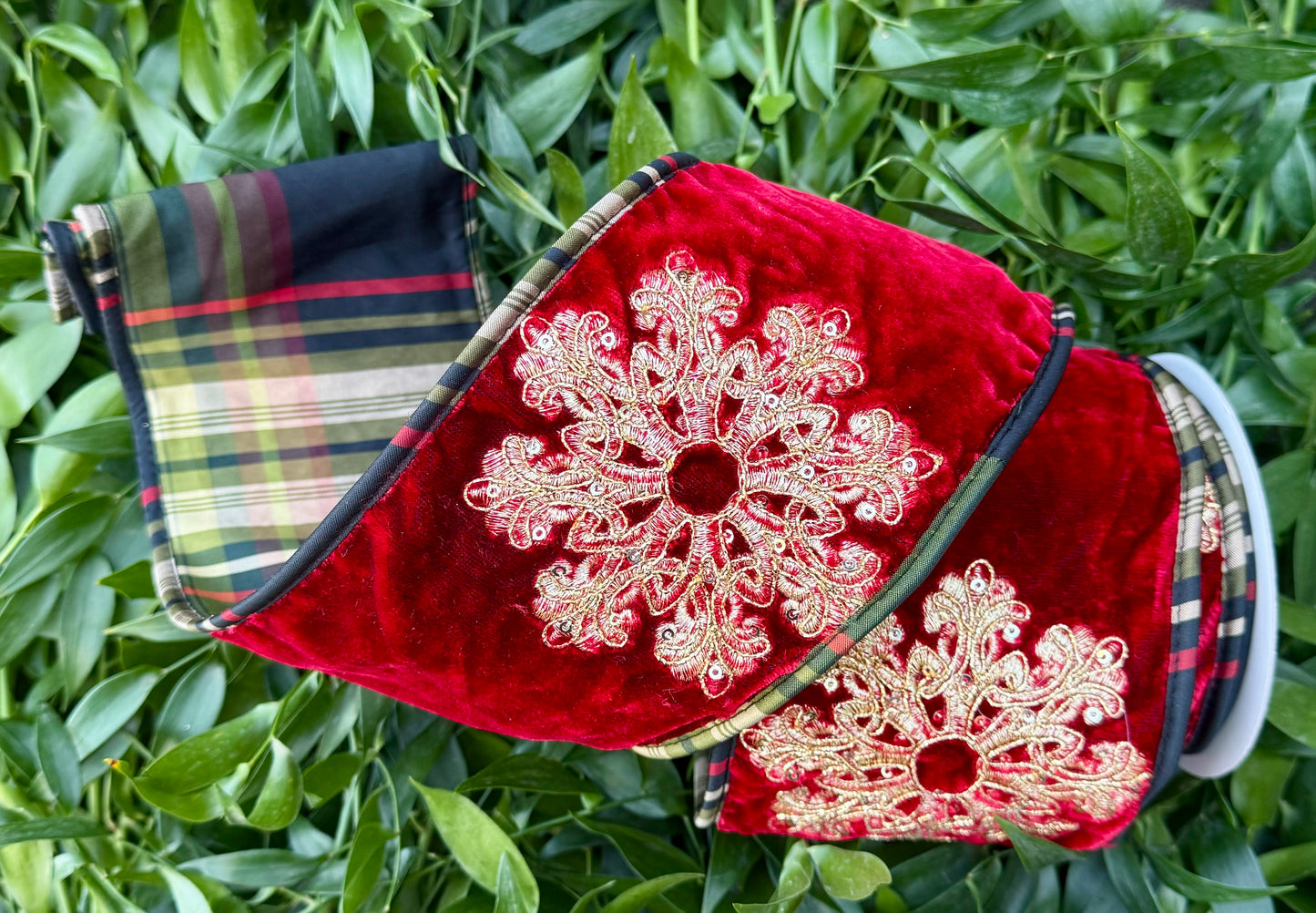 JME heavy wire ribbon. Red velvet with gold embroidered snowflakes backed with black and green plaid and piped down the sides. 4“ x 5 yards.