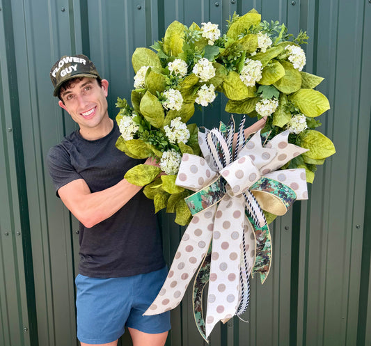 JME handmade magnolia and viburnum wreath. Paired with a JME hand tied bow. About 28 inches wide.