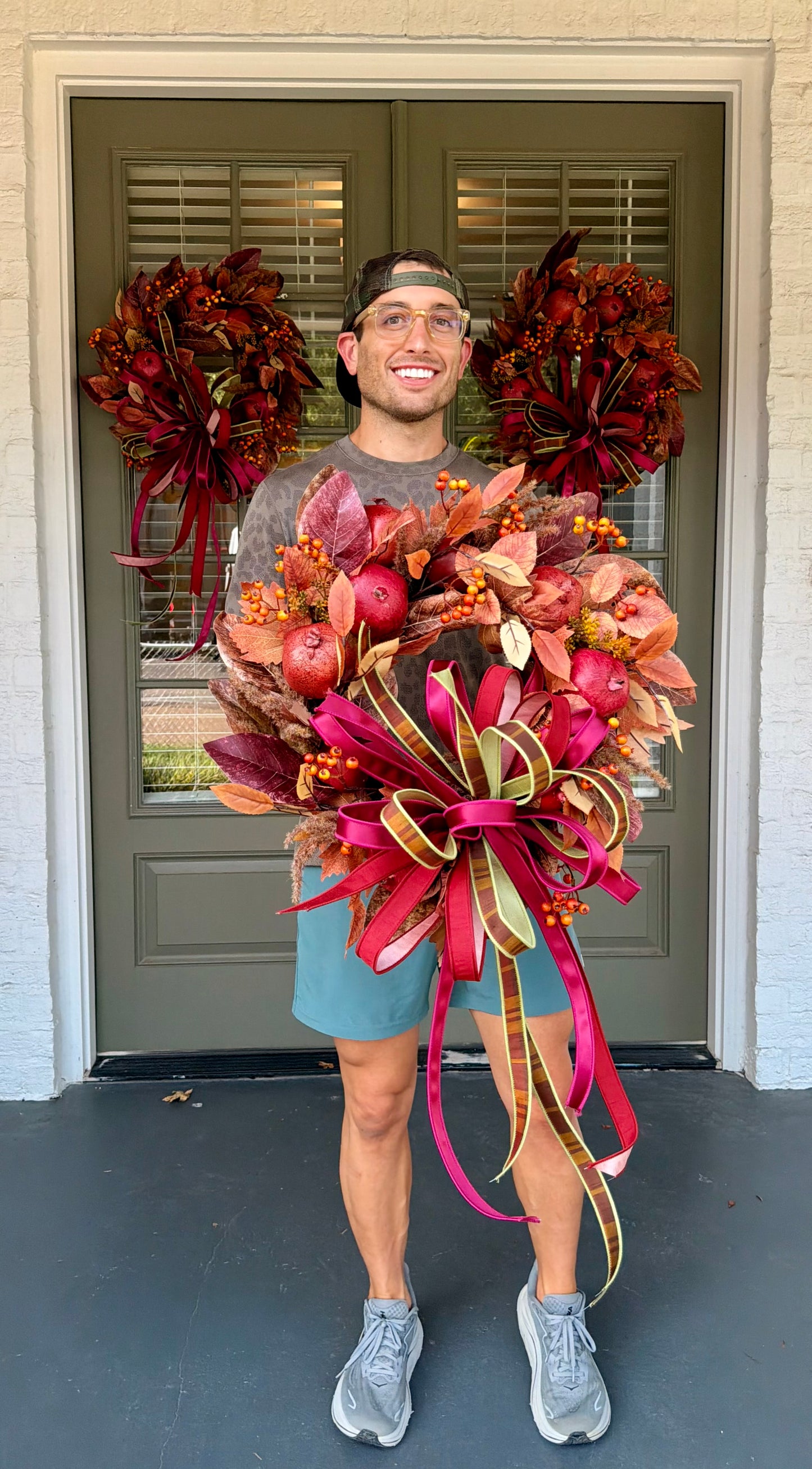 Faux POMEGRANATE fall wreath with a JME hand tied bow of an assortment of 1in ribbons. About 24 inches wide. Some fluffing might be required upon receiving.