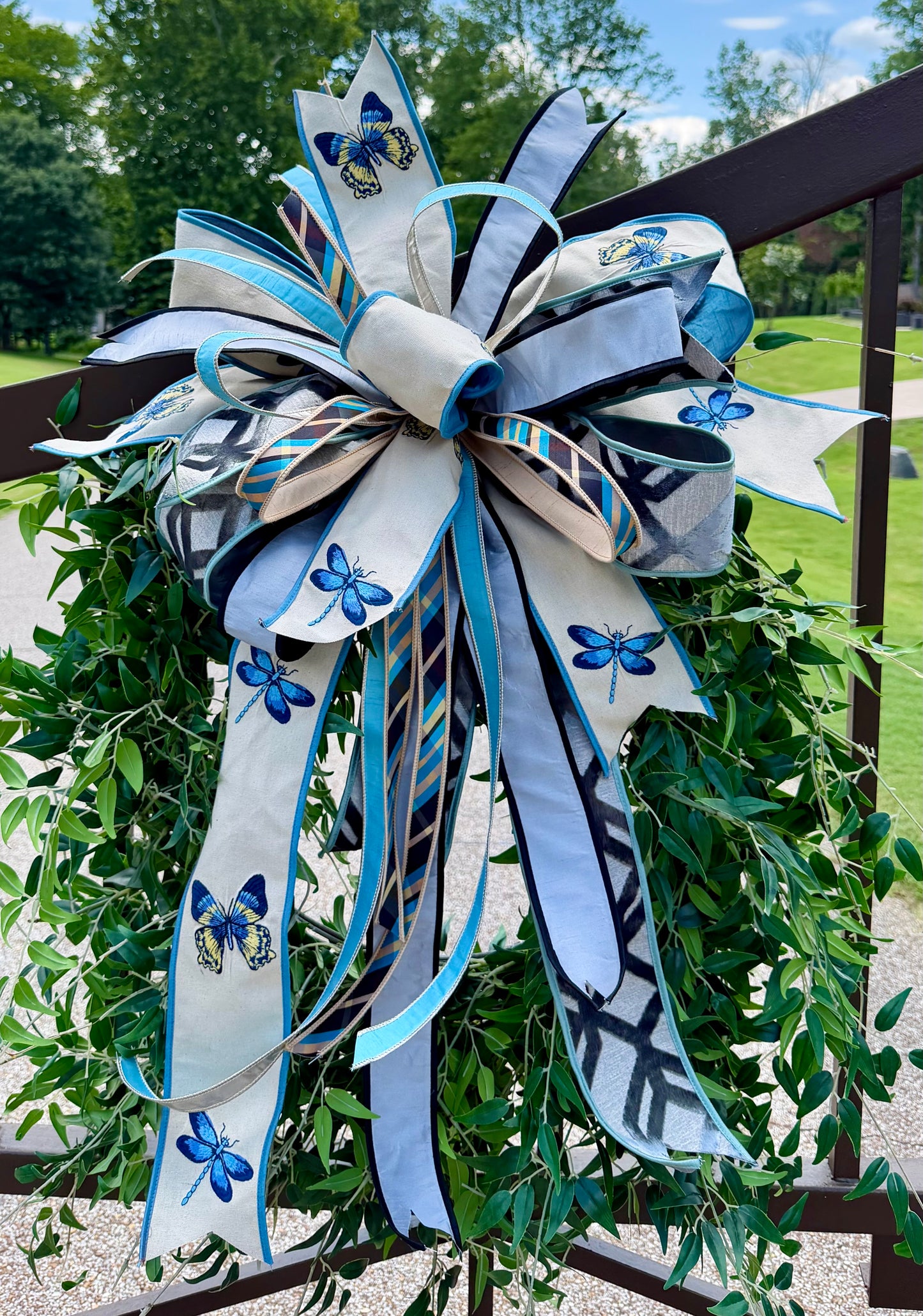 Large JME hand tied bow using embroidered butterfly and dragonfly ribbon paired with other JME HEAVY wired ribbons. About 22 inches wide by 33 inches long. *Some fluffing may be required upon receiving.