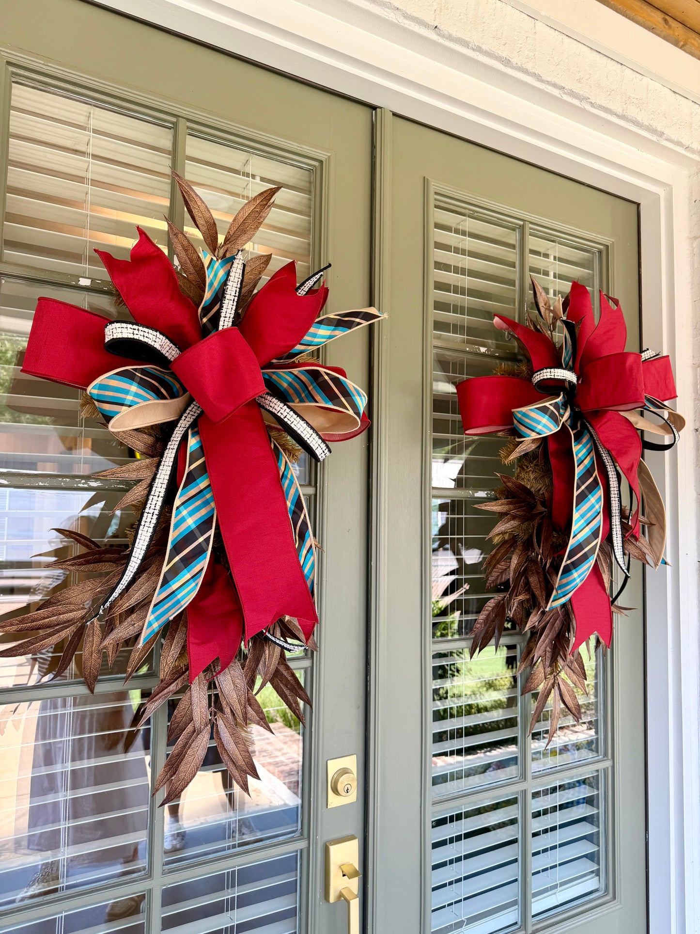 JME faux swag made of BRONZE Bay Leafs  and paired with a JME bow of blue bias plaid ribbon and coordinating colors. About 3 feet long and 21 inches wide. Some fluffing may be required upon receiving.