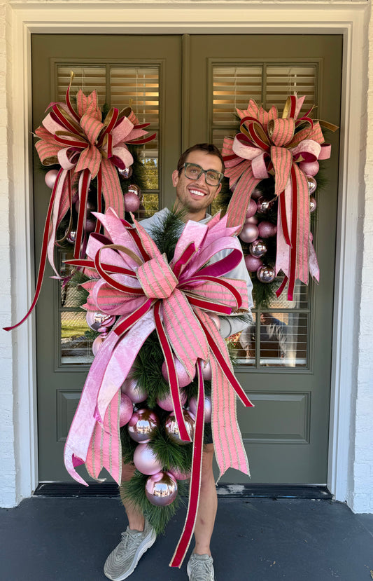 SHADES OF PINK door swag with a hand tied JME bow. Approximately 24 inches wide by 45 inches long.