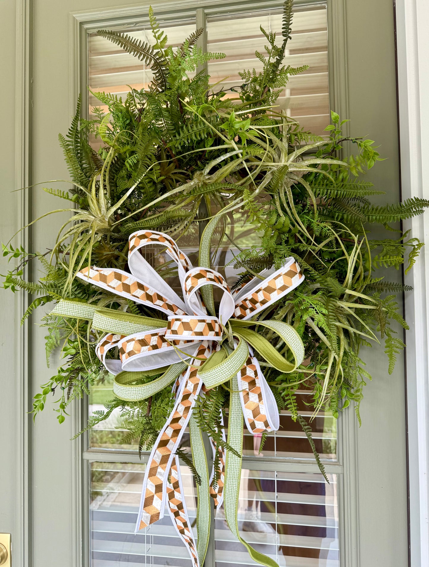 JME faux Succulent and fern wreath. With a JME ribbon bow! Around 24 inches wide.