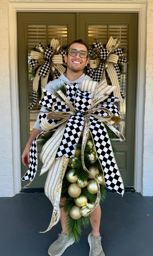 BLACK/WHITE/GOLD/CREAM door swag with a hand tied JME bow. Approximately 24 inches wide by 45 inches long.