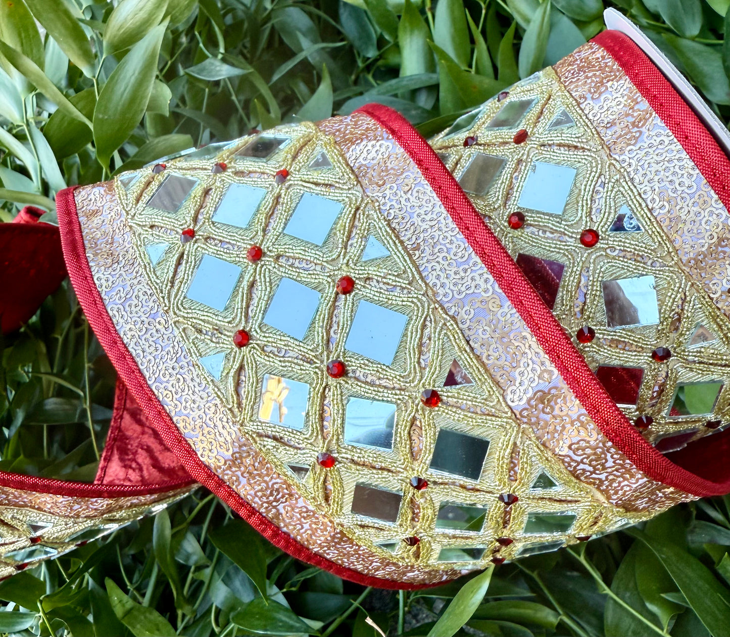 JME heavy wired ribbon. Gold sequin on red metallic with a diamond mirrored band down the center. Backed with red metallic and piped with red metallic. 4” x 5 yards.