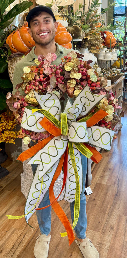 JME FALL WREATH. made with faux metallic leaves and crab apples. Tied with a JME bow. About 24 inches wide.