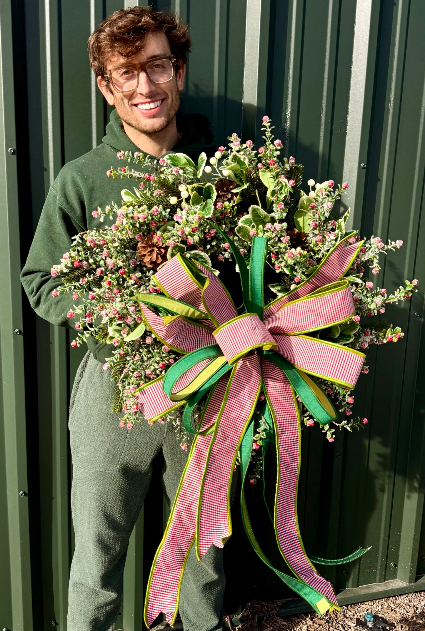 Faux Red snow berry and mixed foliage wreath. Handmade by JME paired with a JME handtied bow. About 24 inches wide.