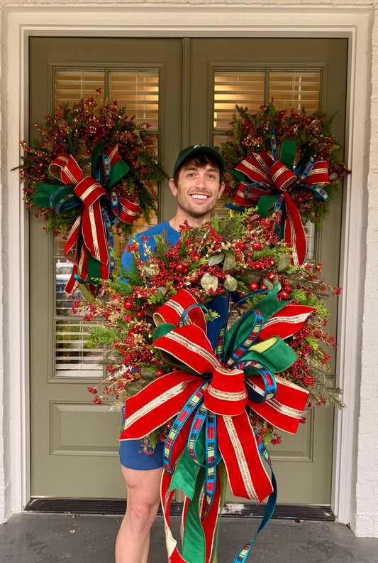 Red jingle bell JME handmade wreath with a JM nutcracker inspired bow. About 24 inches wide.