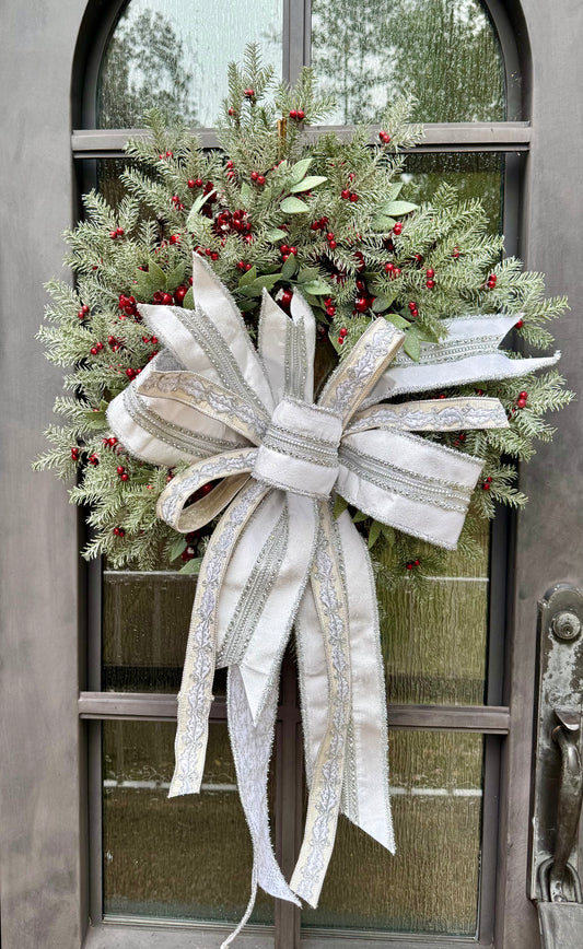 Sweet and soft for the holidays. JME hand made wreath made of red berries, and winter foliage, paired together with a JME hand tied bow of whites, silvers, and holly ribbon. Approximately 24 in.