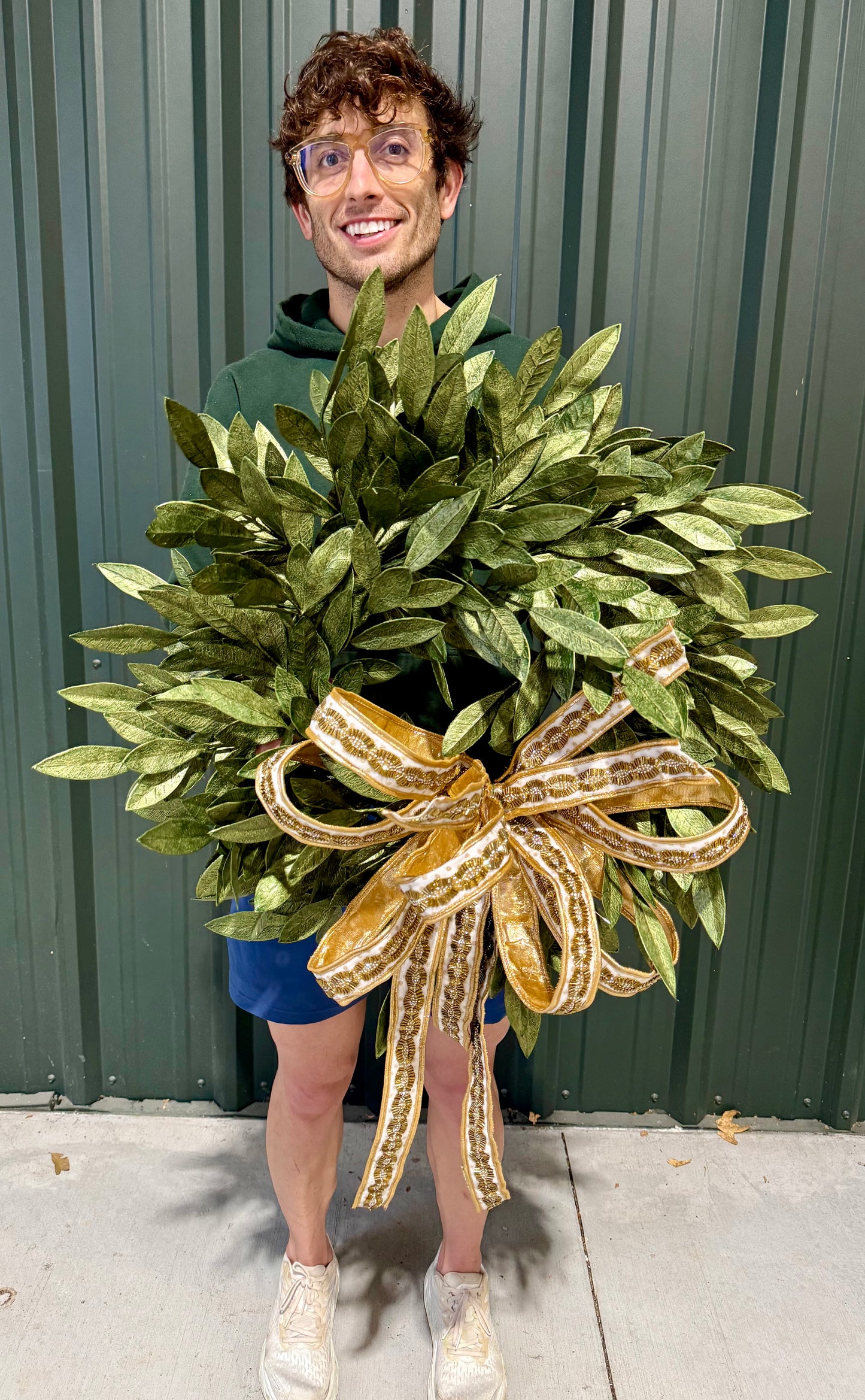 24 inch green and faux gold bay leaf wreath paired with a JME handtied bow.