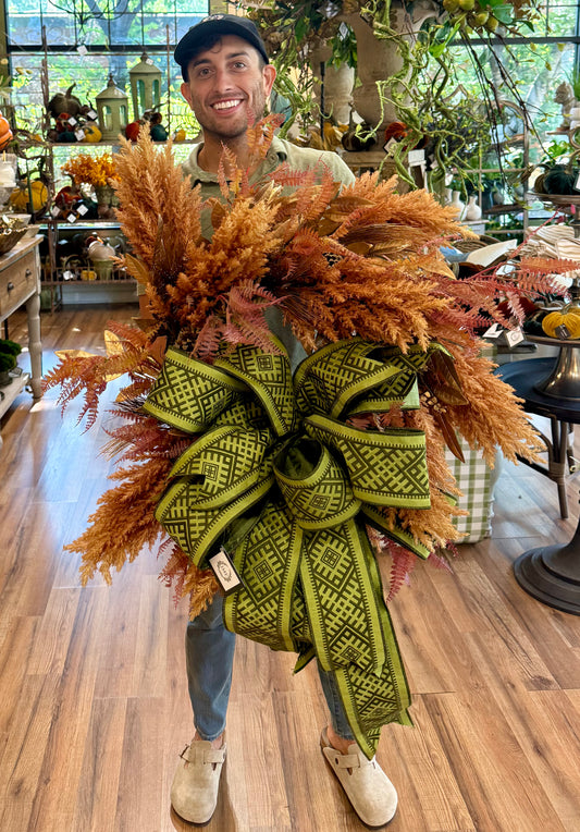 JME MADE faux fall pampas grass wreath with an JME embroidered bow. About 25 inches wide.