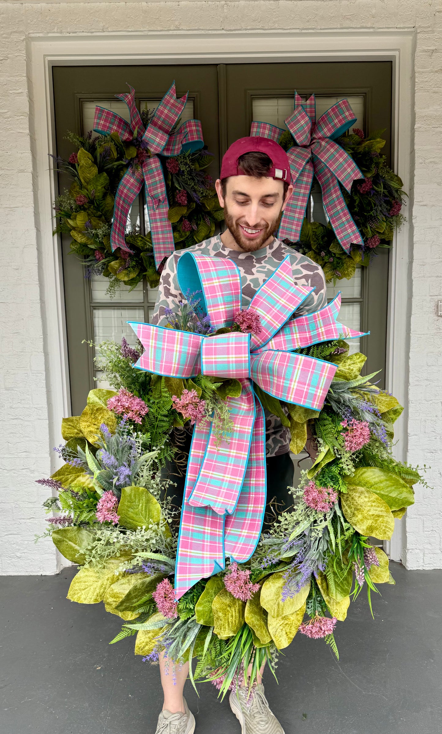 Pink and blue plaid bow wreath with spring flowers and magnolia leaves. Hand made by JME. 26inches wide