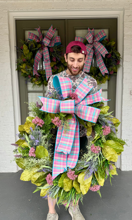 Pink and blue plaid bow wreath with spring flowers and magnolia leaves. Hand made by JME. 26inches wide