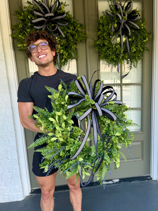 JME Faux mixed greenery with BLUEBERRIES and a JME HAND TIED black/white checked BOW.  About 24inches wide.
